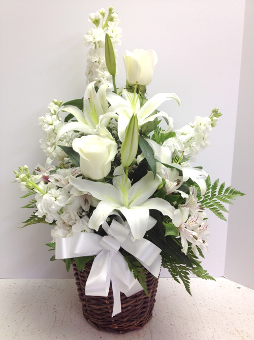 White funeral flower arrangement in basket